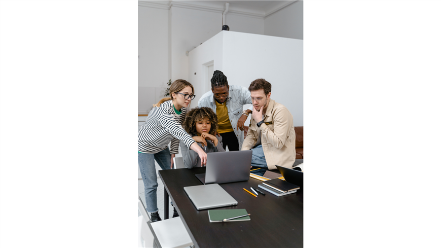people working in front of a laptop at a table people working in front of a laptop at a table